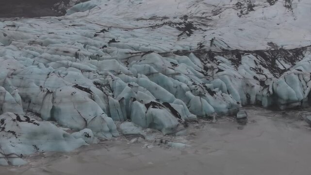 アイスランドの氷河末端と氷河湖を空撮、火山灰の縞模様が刻まれた青い氷（Iceland Glacier Terminus Aerial 4K）