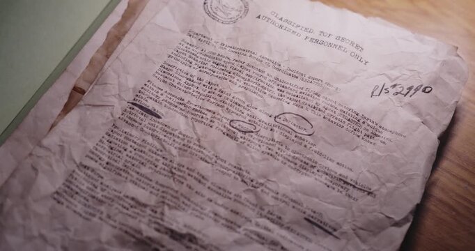 Staged close-up of a folder opening to reveal aged, distressed typewritten papers presented as declassified UFO archive documents.