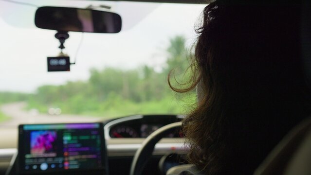 A female driver operates her vehicle on a rural road during a daytime trip, with a dashcam recording the journey from an interior passenger perspective.