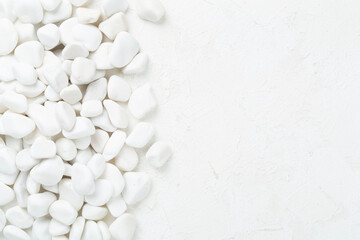 White pebble stones on concrete background, top view © Liami