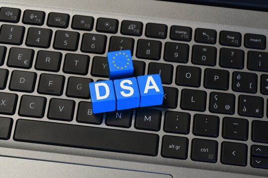 Digital Services Act DSA acronym and European Union flag on blue cubes on laptop keyboard, EU internet regulation and policy concept