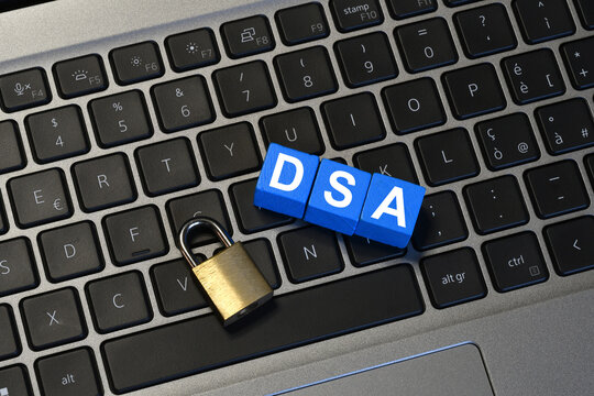 Digital Services Act DSA acronym on blue cubes with padlock on laptop keyboard, internet regulation and data security concept