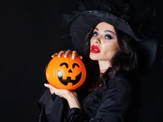 Beautiful young woman wearing witch costume holding a broomstick © yellowj