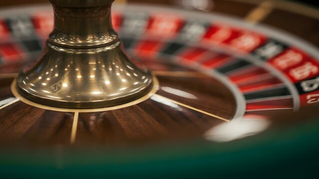 Close-up of a roulette wheel's spindle and betting layout at a casino table