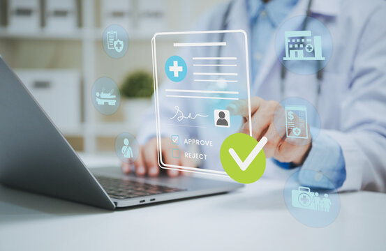 Doctor reviewing digital health insurance approval on laptop managing patient eligibility medical claims electronic records reimbursement and healthcare administration.
