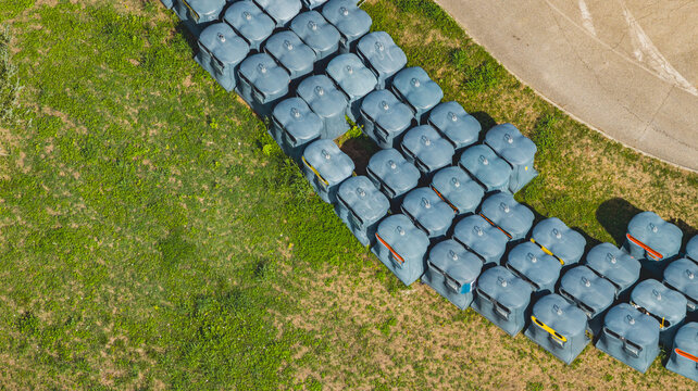 Aerial view of large waste collection containers at a recycling facility, showcasing municipal waste management and circular economy infrastructure in Le Pouzin, Auvergne-Rhone-Alpes, France.