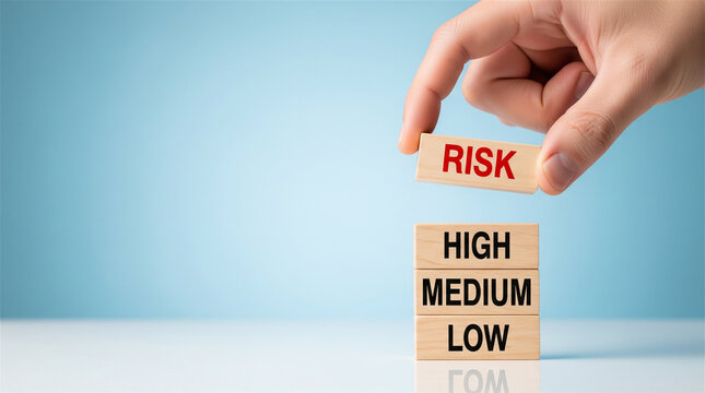 Person placing a block labeled risk above a tower showing high, medium, and low categories against a blue background.