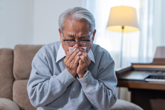 Elderly man sneezing suffer from catching cold