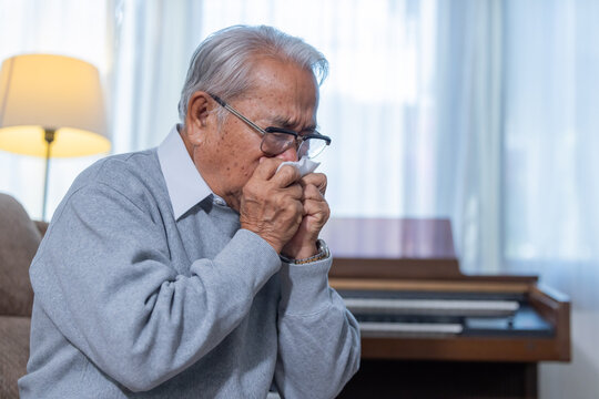 Elderly man sneezing suffer from catching cold