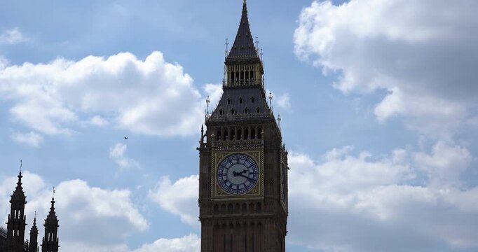 Big Ben clock tower with birds flying by in London, England
