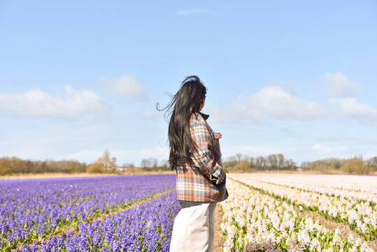 Woman Standing in Front of Dutch Flower Fields in Famous Bollenstreek Region Near Amsterdam, Netherlands