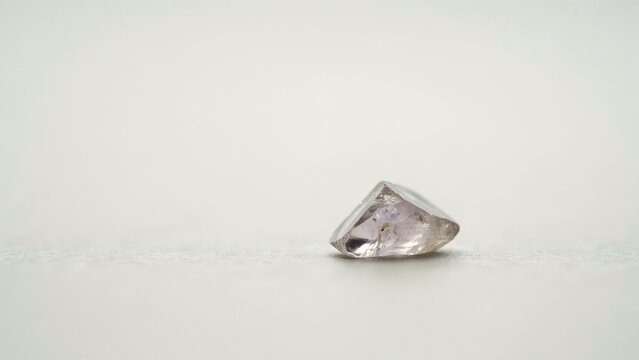 Close-up of a rough quartz crystal on white background with soft shadows