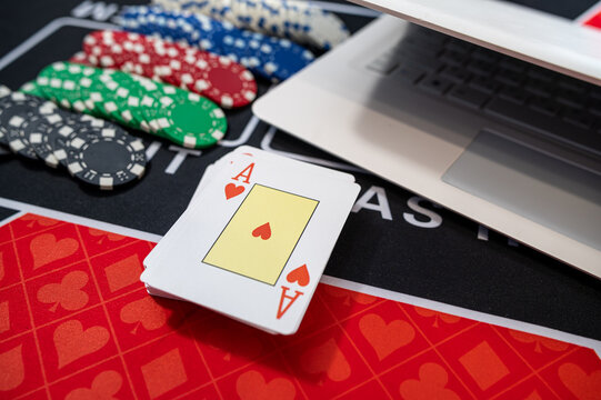 Top View of Laptop Keyboard with Four Aces Poker Cards and Multi Color Tokens for Web Gambling