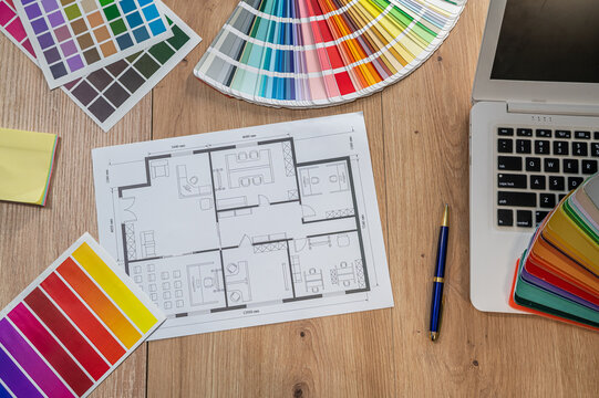 Top View Interior Design Workspace with Laptop Blueprint Floor Plan and Color Swatch Palette