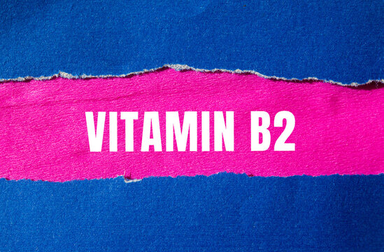 Vitamin B2 message written on ripped torn paper background. Conceptual Vitamin B2 symbol. Copy space.