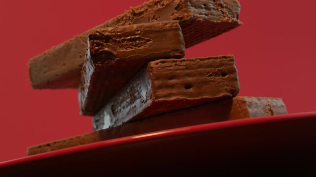 Chocolate wafers on a red plate and a red background. Сonfection, sweets and candies. Tasty and delicious food.