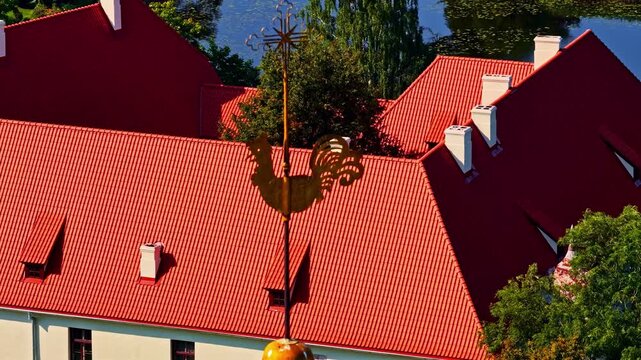 Aerial view of Jaunpils Castle with its distinctive red tiled roof and rooster weather vane in Jaunpils, Tukums Municipality, Latvia.