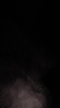 Vertical video. Thin Smoke Drifts Upward Against a Black Background, Creating a Moody Atmospheric Abstract Texture