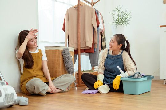 Young Asian Women Cleaning Home Together with Vacuum Cleaner and Household Supplies