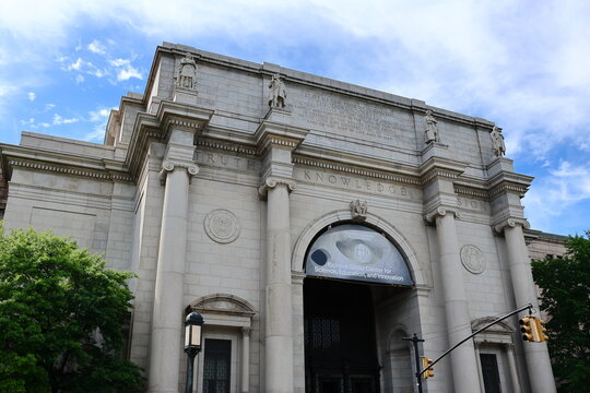 New York, USA - May 27, 2026: Richard Gilder Center for Science, Education, and Innovation at the American Museum of Natural History, framed by trees and blue sky.