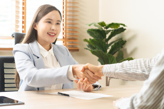 Successful job interview and recruitment concept, asian young woman with professional HR manager shaking hands with a selected candidate after a positive career hiring agreement in office.