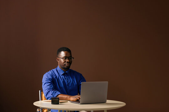 Man Working on a Laptop at Table