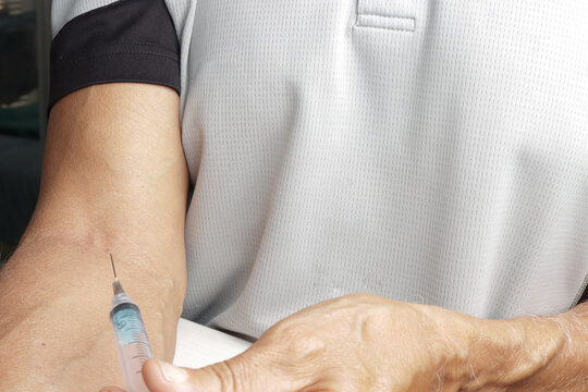 Man Injecting Himself with a Syringe in Arm