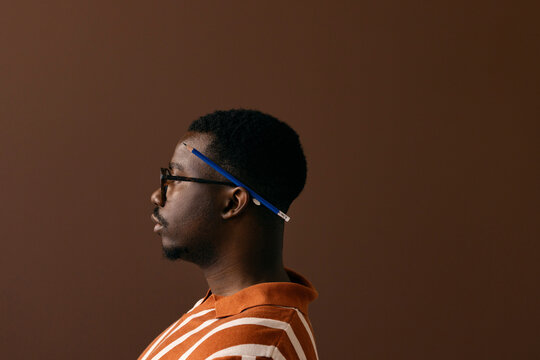 Profile Portrait Of Man Wearing Glasses With Pencil Behind His Ear
