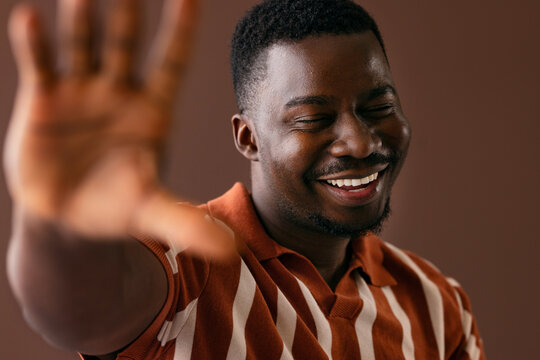 Smiling Young Man Reaching Out in Casual Portrait