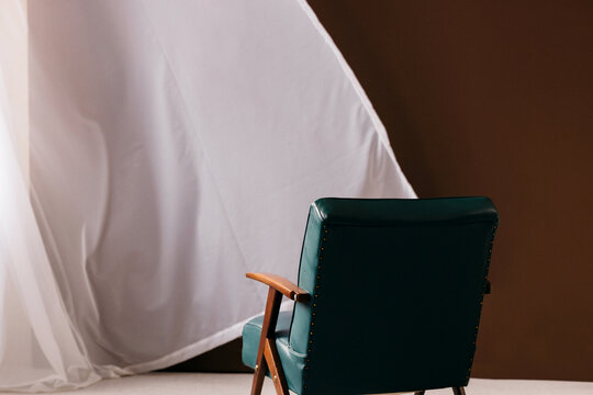 Empty Green Armchair, a Curtain, a Brown Wall