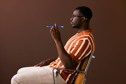 Thoughtful Man Holding Pencil While Seated in Profile