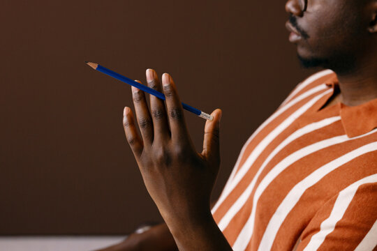 Man Holding Blue Pencil Between Fingers While Thinking