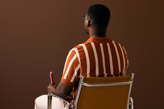 Back View of a Man Sitting in Striped Polo Shirt