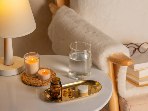 Cozy bedside table with candles, water, and wellness items