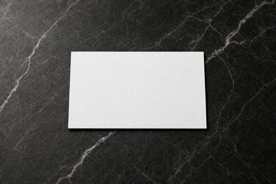 tarjeta blanca est&aacute; apoyada sobre una superficie de m&aacute;rmol oscuro, sin texto ni logotipos