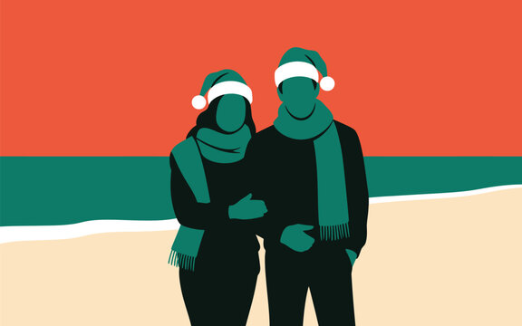 Couple wearing santa hats and winter scarves standing together on beach