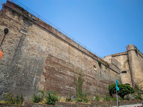 Historic Casbah of B&eacute;ja&iuml;a fortress with weathered red-brick walls and protective ramparts under a clear bright blue sky