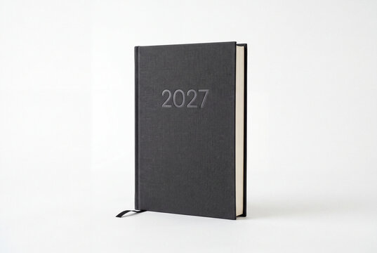 A black 2027 diary or planner with embossed year number and a ribbon bookmark on a white background