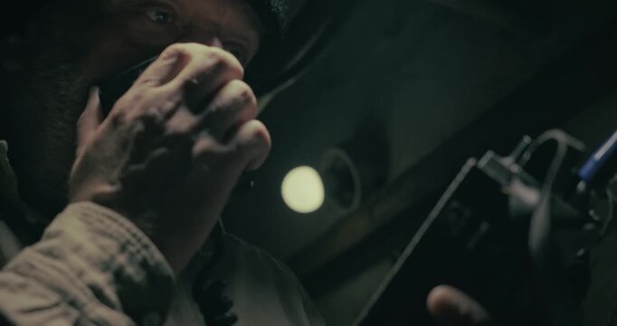 Military personnel communicates on a vintage radio set inside an underground command bunker, creating a dark cinematic wartime communication scene.