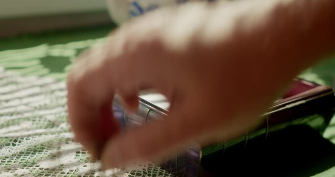 A person opens a small antique jewelry box revealing personal handwritten letters in soft ambient cinematic light.