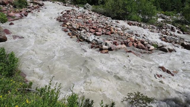 A wild and powerful glacier mountain river rushing through rocky terrain in Svaneti Georgia, depicting natural water flow and environmental conservation themes