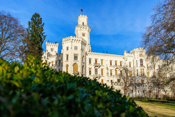 Majestic white castle amid lush gardens under clear blue sky © Iurii Gagarin