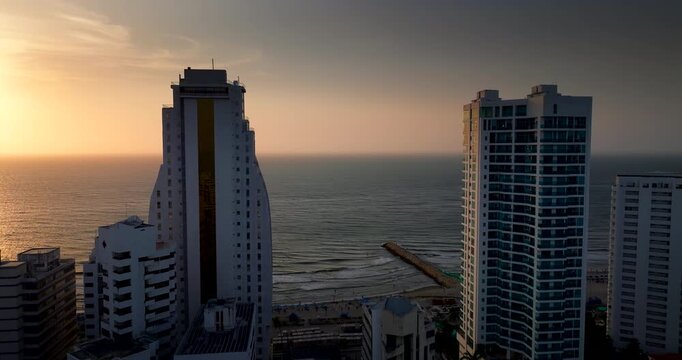 Bocagrande peninsula, high-rise skyscrapers, and beach at sunset in Cartagena, Colombia. Aerial drone view
