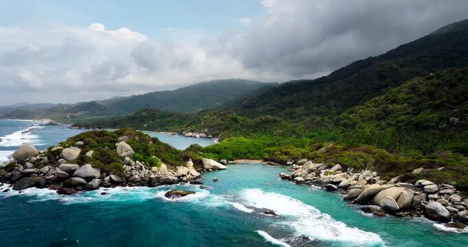 Drone pullback reveals scenic Tayrona National Park white sand beaches, Colombia
