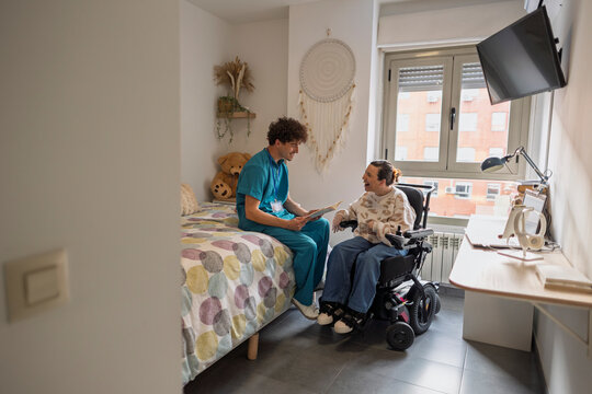 Caregiver talking with patient in electric wheelchair