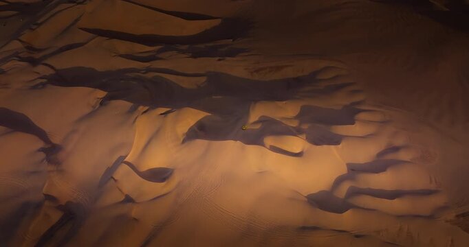 Dune buggy driving across sand dunes in Huacachina desert in Ica, Peru. Aerial drone view