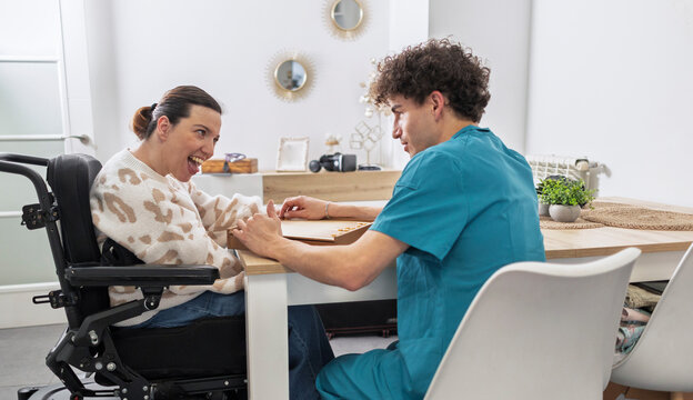 Woman with disability interacting with male caregiver at home
