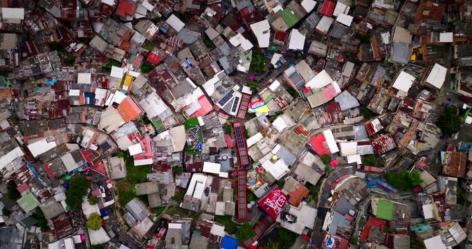 Aerial top-down view over dense tin roofs and brick houses in Comuna 13 in Medellin, Colombia
