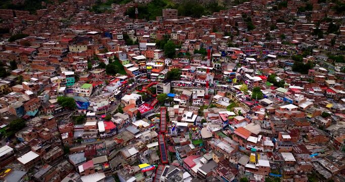 Drone view over colorful houses and outdoor escalators in Comuna 13 in Medellin, Colombia. Aerial backward