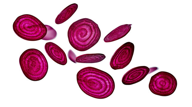 Fresh vibrant purple beetroot slices falling in midair